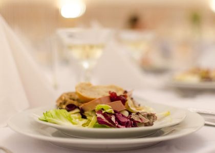 Plate of gourmet salad with bread on a elegantly set restaurant table, perfect for upscale dining experiences.