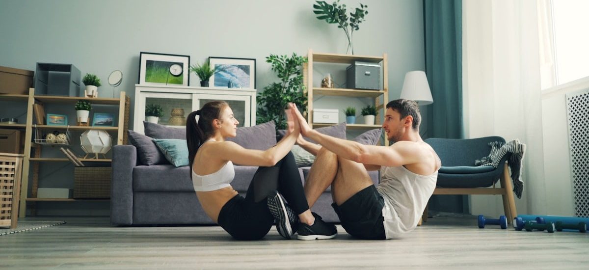 a man and woman sitting on the floor in a living room